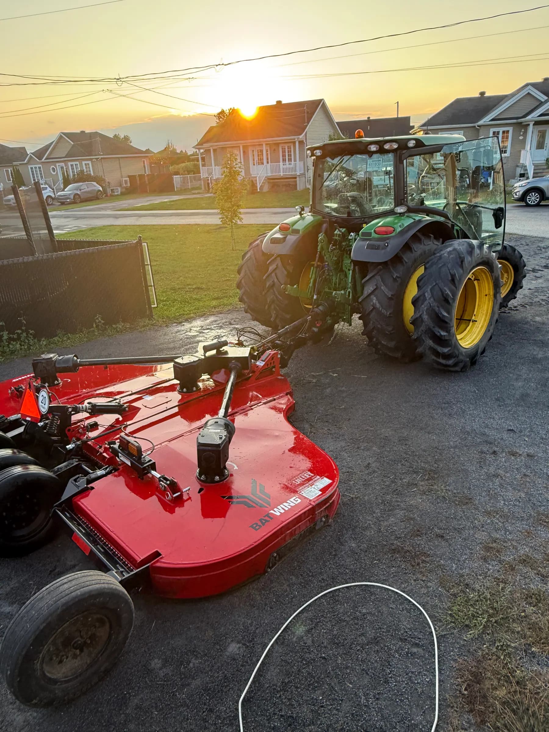 Tracteur John Deere et gyrobroyeur Batwing de F.A.D.S. au coucher du soleil